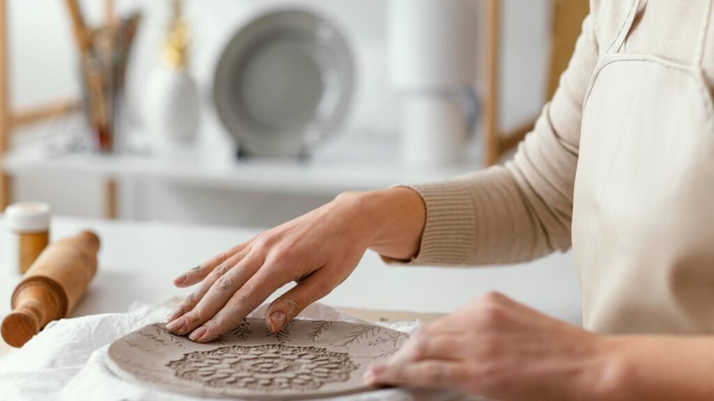 Hands decorating a ceramic plate