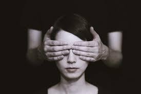 Hands covering a person's eyes, representing assumptions made about blindness