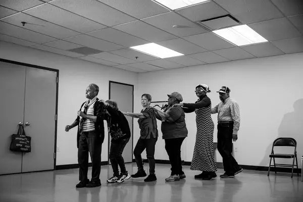 Group of participants in a theatre workshop standing in a circle